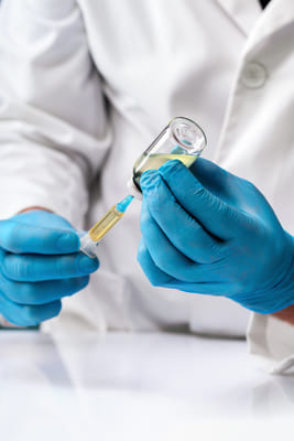 Врач набирает медикамент шприцом из пузырьки